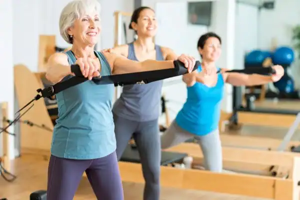 Toning Arms After 60: Empowering Womens Fitness Through Effective Weight Training 2 older woman doing weight training Wentworth and resistance in the gym to tone upper arms