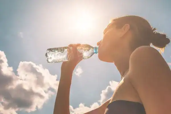 Image of woman drinking water to hydrate Wentworth after run.