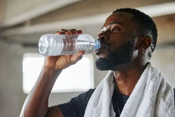 Image of man drinking water to improve hydration Wentworth after work out.